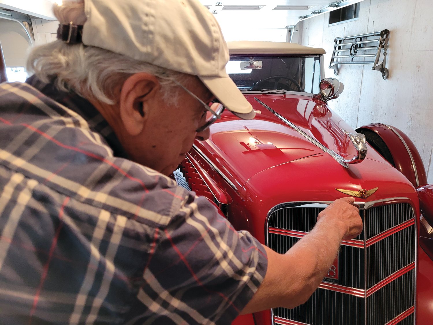 SHOWSTOPPER: John Ricci points out the details that differentiate his 1934 Cadillac from the far more common 1935 model; a slightly different hood ornament, the grill’s mesh bottom, and the bi-plane and bullet bumpers.